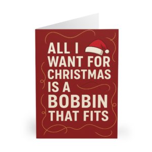 Funny sewing Christmas card with red background, Santa hat and bold text “All I Want for Christmas Is a Bobbin That Fits” — festive card for sewing lovers | by T Larkin.